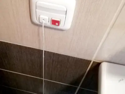 Ovládací prvek s připojeným táhlem na stěně koupelny